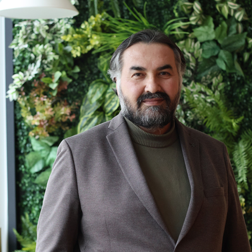 İsa Uysal’ın yeşil bitki duvarı önündeki portresi